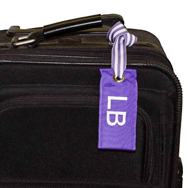 Personalized light purple luggage tag shown on suitcase