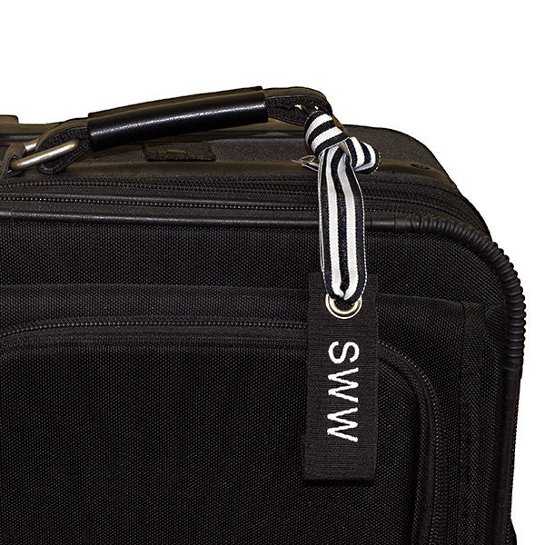 Black mini luggage tag shown on suitcase | YourBagTag