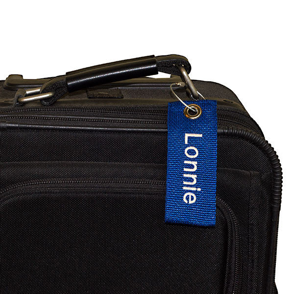 blue extreme bag tag with white text shown on suitcase