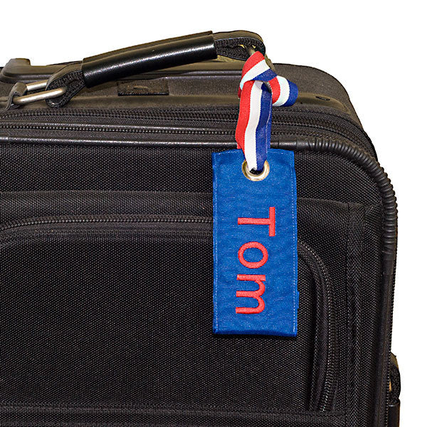 Custom blue luggage tag on suitcase from YourBagTag