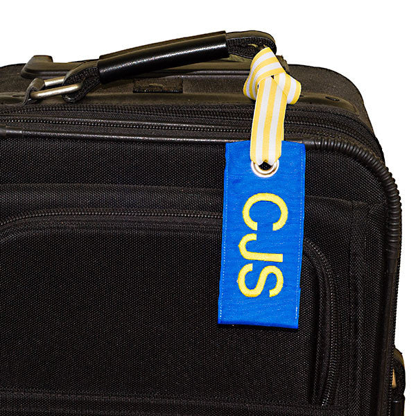 custom blue luggage tag shown on black suitcase