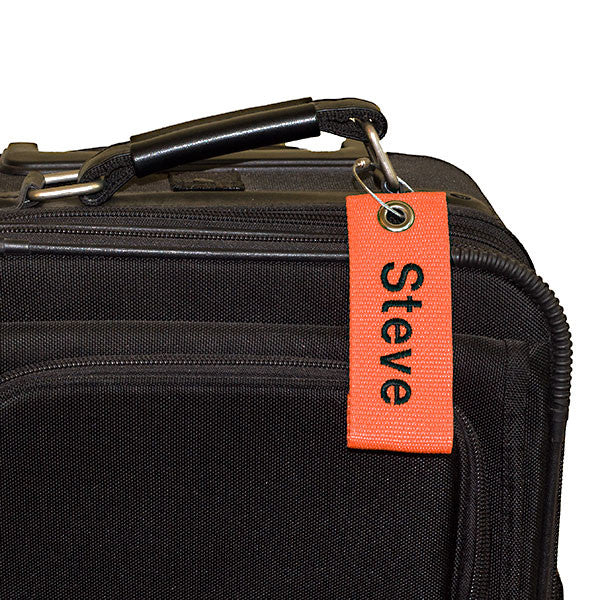 orange extreme bag tag with black text shown on bag