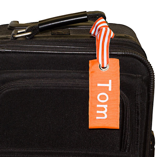 orange custom luggage tag shown on black suitcase