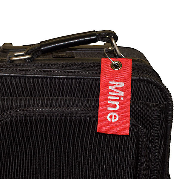 red extreme bag tag with white text shown on bag