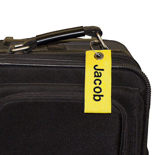 yellow extreme bag tag with black text shown on luggage